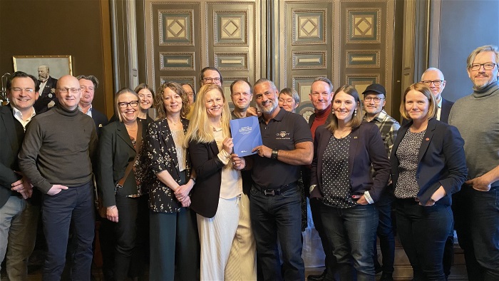 Människor i grupp, håller upp en bok