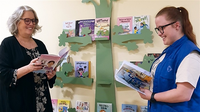 Bild på Sara Frank och Lovisa Larsson som bläddrar i varsin bok.