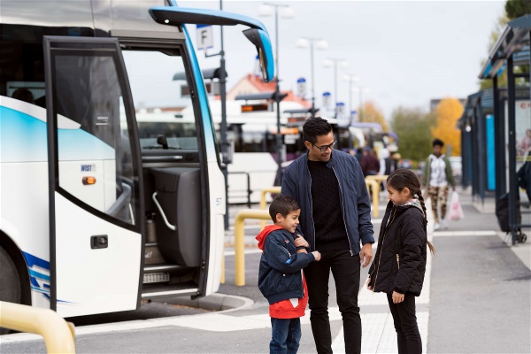 Familj vid busstation. Foto Jonas Westling. 