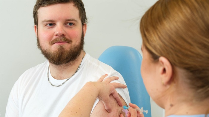 Ung man får vaccin.