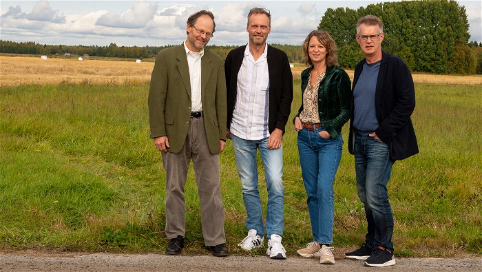 Projektgruppen står vid en väg ute i ett öppet landskap