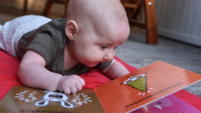ett spädbarn som tittar i en bok